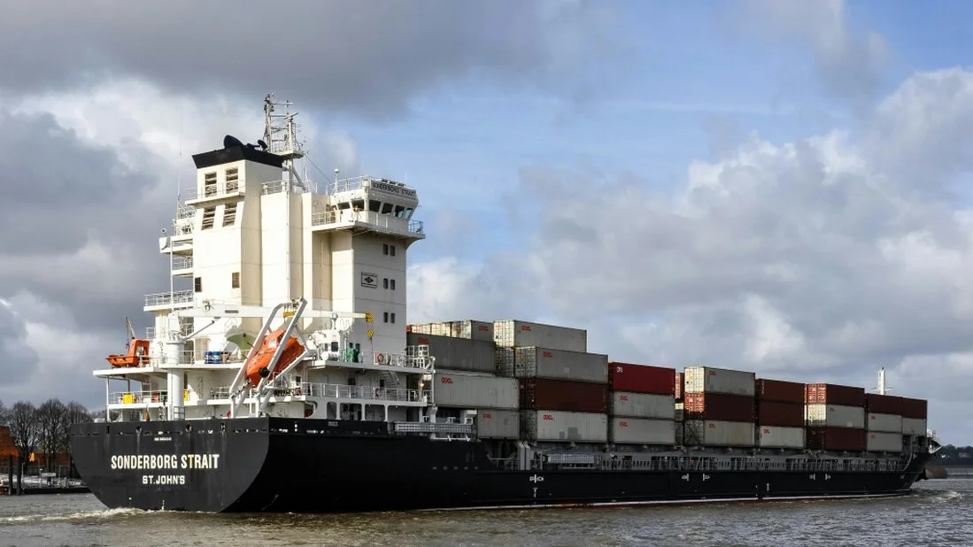 Große Maschine in einer schweren Export-Holzkiste vor einem Container